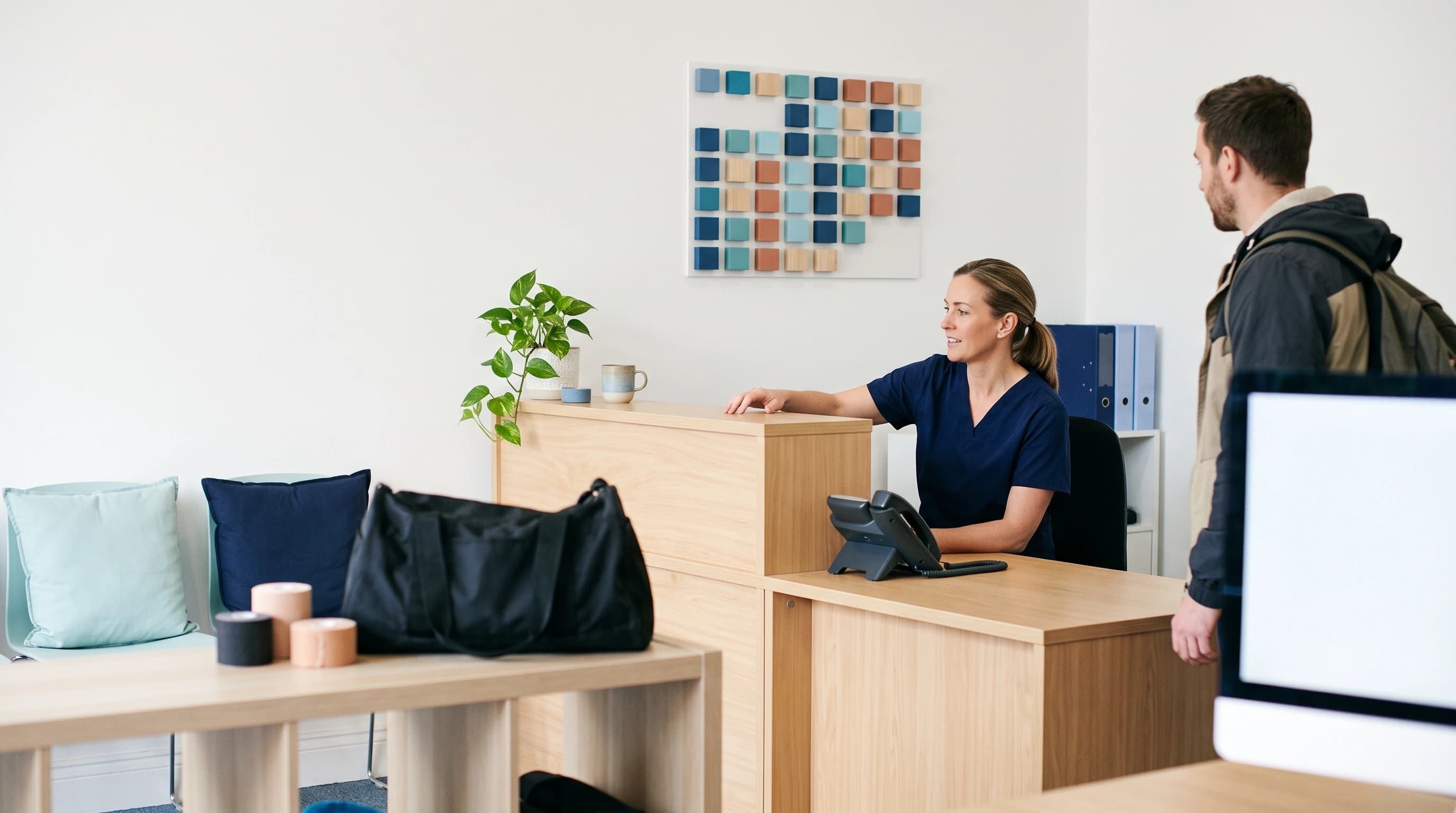 Photo of a sports-medicine clinic reception running smoothly with strapping tape and a sports bag on a shelf