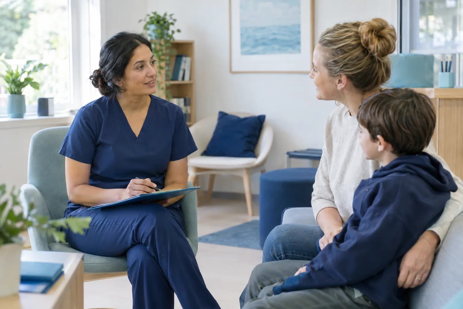 Photo of a therapist talking with a parent and child in a clinic waiting area